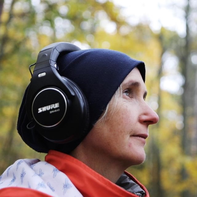 Karen Power wearing headphones and a black beanie.