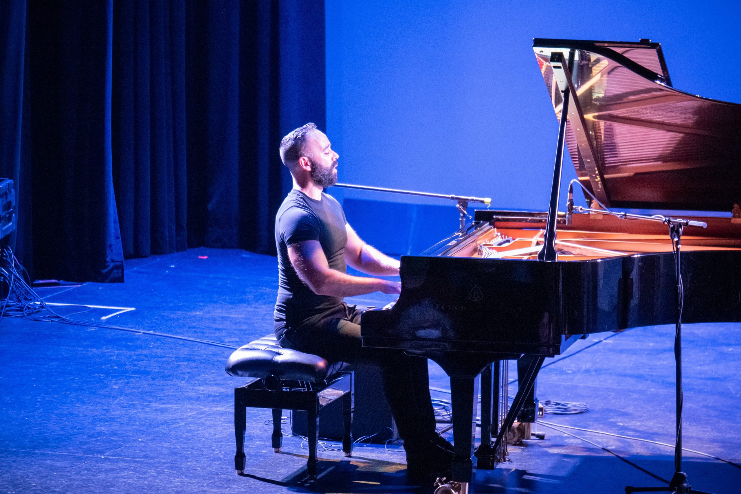 Adam Tendler playing piano on stage.