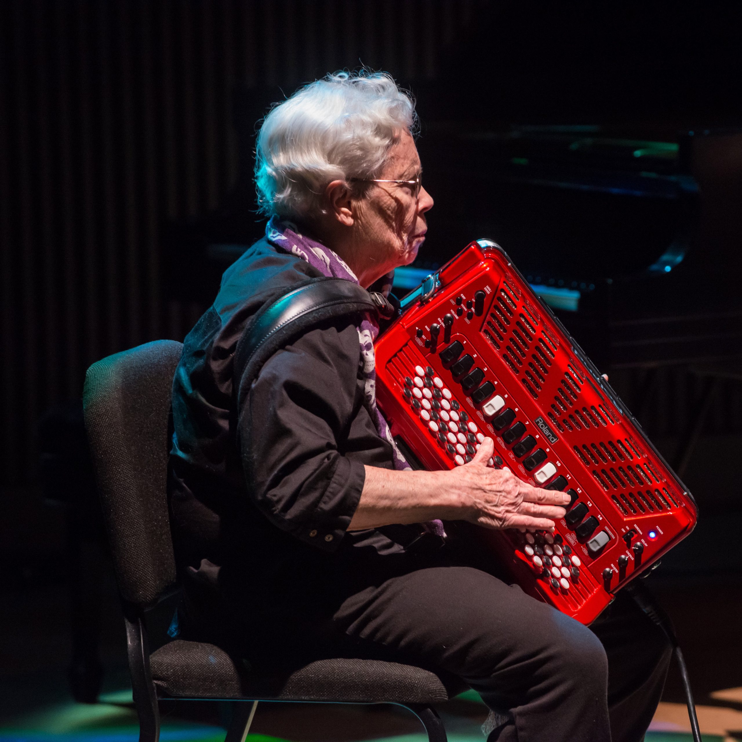 Pauline Oliveros playing a red accordion